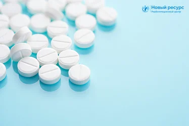 Белые таблетки рассыпаны на голубом фоне